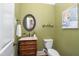 Charming powder room with a unique vanity, round mirror, and decorative painting at 8405 Hempton Cross Dr, Wake Forest, NC 27587