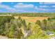 An aerial perspective shows a residence surrounded by trees, a nearby field, and a serene sky above the landscape at 852 Fred Wilder Rd, Franklinton, NC 27525