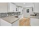 Kitchen boasts white cabinets, granite counters, tile backsplash, and stainless steel appliances at 852 Fred Wilder Rd, Franklinton, NC 27525