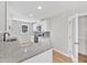 Open-concept kitchen featuring white cabinetry, granite countertops, and tile backsplash at 852 Fred Wilder Rd, Franklinton, NC 27525