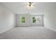 A bright, large bedroom with neutral walls and carpet with two large windows at 8621 Neuse Club Ln # 106, Raleigh, NC 27616