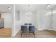 Inviting dining space with wood floors, modern lighting fixture, and access to kitchen at 8621 Neuse Club Ln # 106, Raleigh, NC 27616