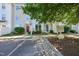 Townhouse exterior featuring neutral siding, well-kept landscaping, and visible community signage at 8621 Neuse Club Ln # 106, Raleigh, NC 27616