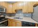 Traditional style kitchen with wooden cabinets, stainless steel appliances, and gray tiled backsplash at 8621 Neuse Club Ln # 106, Raleigh, NC 27616