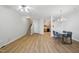 Bright living room with wood floors, a ceiling fan, stairs, and dining area that flows into the kitchen at 8621 Neuse Club Ln # 106, Raleigh, NC 27616
