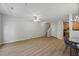 Open-concept living room boasts wood floors, ceiling fan, and staircase leading to the upper level at 8621 Neuse Club Ln # 106, Raleigh, NC 27616