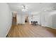 Spacious living room with staircase, wood flooring, and dining area leading to the kitchen at 8621 Neuse Club Ln # 106, Raleigh, NC 27616
