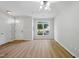 Bright living room features wood floors, a large window, and a white front door at 8621 Neuse Club Ln # 106, Raleigh, NC 27616