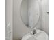 Compact powder room featuring an oval mirror and a sleek sink at 8621 Neuse Club Ln # 106, Raleigh, NC 27616