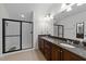 Bathroom with granite counters, dual sinks, walk-in shower with glass door and great lighting at 9164 Wooden Rd, Raleigh, NC 27617