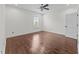 Spacious bedroom with gleaming hardwood floors and a modern ceiling fan at 9164 Wooden Rd, Raleigh, NC 27617