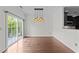 Bright dining area with a modern chandelier, hardwood floors, and access to a private balcony for indoor-outdoor living at 9164 Wooden Rd, Raleigh, NC 27617