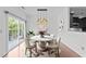 Charming dining room with a modern chandelier, a marble table, and sliding glass doors to a private balcony at 9164 Wooden Rd, Raleigh, NC 27617