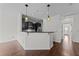 Open-concept design with stylish pendant lights, a breakfast bar, and a view into the kitchen and dining area at 9164 Wooden Rd, Raleigh, NC 27617