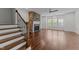 Bright living room with stone fireplace, hardwood floors, and staircase at 9164 Wooden Rd, Raleigh, NC 27617