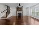 Bright living room featuring a stone fireplace, ceiling fan, and gleaming hardwood floors at 9164 Wooden Rd, Raleigh, NC 27617