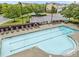 An aerial view of the community pool with lounge chairs, parking lot, and mature trees at 9164 Wooden Rd, Raleigh, NC 27617