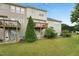 View of townhome back with a nice lawn and deck on the second story, perfect for outdoor relaxation at 9808 Rainsong Dr, Wake Forest, NC 27587