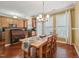Bright dining room features hardwood floors, a wooden dining set, and opens to the kitchen at 9808 Rainsong Dr, Wake Forest, NC 27587