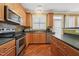 This kitchen features stainless appliances, ample wood cabinets and black countertops at 9808 Rainsong Dr, Wake Forest, NC 27587