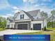 Charming two-story home with a three-car garage, stone accents, and manicured lawn under a sunny sky at 109 Hewitt Woods Dr, Clayton, NC 27527
