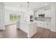 Modern kitchen featuring a large island, stainless steel appliances, white cabinetry, and a window overlooking the backyard at 109 Hewitt Woods Dr, Clayton, NC 27527