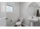 Cozy half bathroom featuring a pedestal sink, round mirror, and decorative window for added privacy at 1102 Latitude Dr, Durham, NC 27713