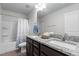 Bathroom featuring a shower-tub combo, double sink granite vanity, and neutral-toned walls at 1102 Latitude Dr, Durham, NC 27713