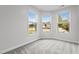 Bright bedroom featuring three large windows providing ample natural light and neighborhood views at 1102 Latitude Dr, Durham, NC 27713