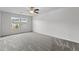 Spacious bedroom with a ceiling fan and a large window offering neighborhood views at 1102 Latitude Dr, Durham, NC 27713