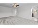 Expansive bedroom with neutral carpet, ceiling fan and a view into an ensuite bathroom at 1102 Latitude Dr, Durham, NC 27713