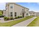 Two-story townhouse with tan siding, a well-maintained lawn and sidewalk at 1102 Latitude Dr, Durham, NC 27713