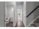 Bright hallway featuring dark wood floors, gray stairs, and access to a bathroom and bedroom at 1102 Latitude Dr, Durham, NC 27713