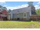 Back of house with large lawn, screen porch, and mature trees and landscaping at 111 Mcdole Cir, Cary, NC 27511