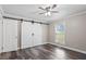 The bedroom has wood-look flooring, a ceiling fan, and a white barn door closet at 111 Mcdole Cir, Cary, NC 27511