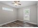 This bedroom has wood-look flooring, a ceiling fan, and two windows providing natural light at 111 Mcdole Cir, Cary, NC 27511