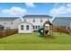 Spacious backyard featuring a well-maintained lawn, a charming playset and patio, perfect for Gathering fun at 1112 Prewitt Ranch Dr, Holly Springs, NC 27540