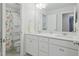 Bathroom with a double sink vanity, white cabinets and a large mirror at 1112 Prewitt Ranch Dr, Holly Springs, NC 27540