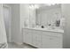 Bright bathroom featuring dual sinks, white cabinetry, neutral paint, and modern fixtures at 1112 Prewitt Ranch Dr, Holly Springs, NC 27540
