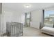 Cozy bedroom featuring neutral colors, a crib, dresser, and comfortable seating with bright sunlight at 1112 Prewitt Ranch Dr, Holly Springs, NC 27540
