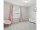 Bright bedroom with large window, pink curtains, and soft carpet at 1112 Prewitt Ranch Dr, Holly Springs, NC 27540