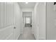 Bright hallway with neutral paint, carpet, doors, and trim leading to various rooms in the home at 1112 Prewitt Ranch Dr, Holly Springs, NC 27540