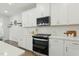 Modern kitchen showcasing white cabinets, stainless steel appliances, and quartz countertops at 1112 Prewitt Ranch Dr, Holly Springs, NC 27540