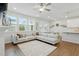 Spacious living room featuring a sectional sofa, ample windows, hardwood floors, and an open layout at 1112 Prewitt Ranch Dr, Holly Springs, NC 27540