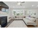 Bright living room with fireplace, large sectional couch, and many windows allowing for natural light at 1112 Prewitt Ranch Dr, Holly Springs, NC 27540
