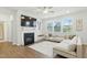 Bright living room with a fireplace, large windows, and a comfortable sectional couch for modern living at 1112 Prewitt Ranch Dr, Holly Springs, NC 27540