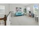 Inviting loft with comfortable blue sofa, natural light, modern decor, and space for relaxation and play at 1112 Prewitt Ranch Dr, Holly Springs, NC 27540