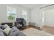 Bright and airy office space with dual monitors, light wood floors, and a comfortable gray futon at 1112 Prewitt Ranch Dr, Holly Springs, NC 27540