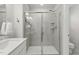 Modern shower with gray tile, glass enclosure, and sleek fixtures in a well-lit bathroom at 1112 Prewitt Ranch Dr, Holly Springs, NC 27540