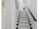 Carpeted staircase leading to the upper level of the home, featuring dark wood handrail at 1112 Prewitt Ranch Dr, Holly Springs, NC 27540